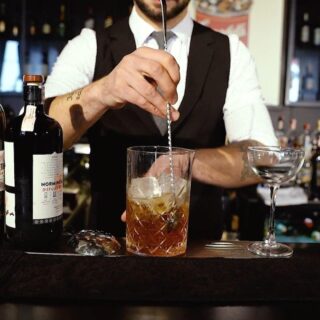 un bartender al bancone finisce di preparare un delizioso drink