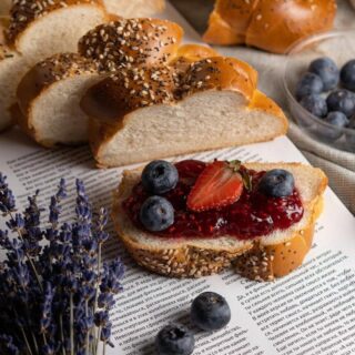 fetta di pane integrale con semi oleosi e marmellata di frutti di bosco con frutta fesca come decorazione